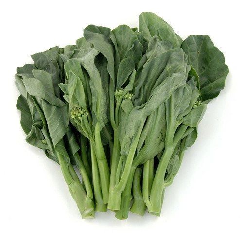Gai lan with green stems, broad leaves, and small florets on a white background.